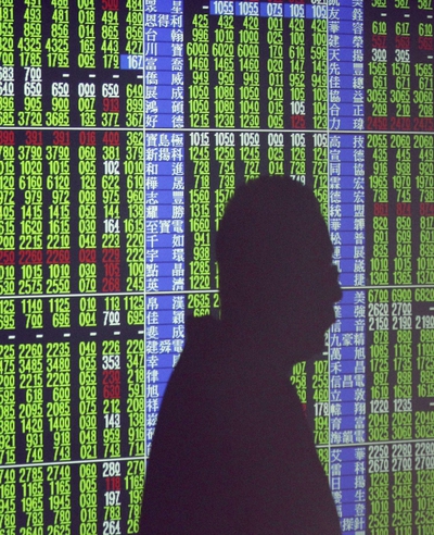 La sombra de un hombre en un luminoso con cotizaciones.