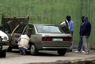 Agentes de la  ertzaintza  inspeccionan al coche del guarda jurado en el que ha sido colocada una bomba lapa.