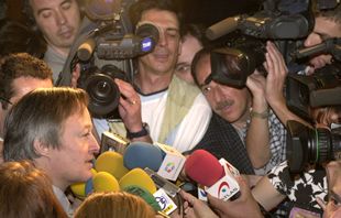 El ministro Josep Piqué, rodeado de periodistas en los pasillos del Senado.
