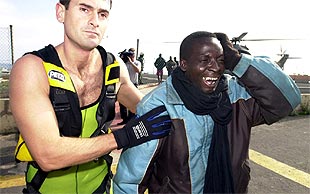 Uno de los 21 inmigrantes llora a su llegada a Puerto Rosario para ser trasladado al hospital.