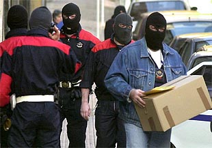 Un  ertzaina , con la documentación incautada en un piso registrado en el barrio bilbaíno de Rekalde.