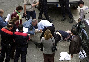 Miembros de las fuerzas de seguridad observan el cadáver del escolta Joseba Andoni U.
