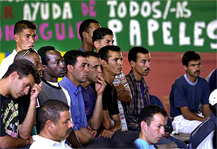 Varios de los inmigrantes encerrados en Sevilla escuchan a sus representates reunidos en asamblea.