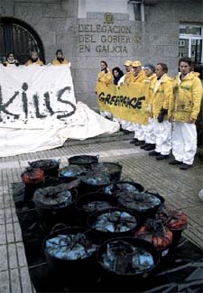 Miembros de Greenpeace han depositado a las puertas de la Delegación del Gobierno en Galicia 16 cubos cargados con fuel para demandar medidas urgentes.