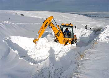 Una excavadora retira nieve de la carretera entre la localidad de Quintanadueñas y Burgos.