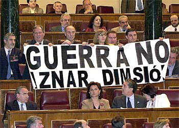 Los diputados de IU sostienen una pancarta contraria a la guerra durante la intervención de José María Aznar.