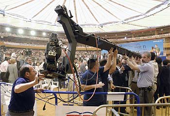 Varias personas levantan la grúa de televisión en la Plaza de Toros de Zaragoza.