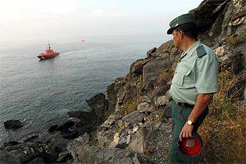 Un guardia civil vigila la costa de la localidad granadina de Salobreña donde se han producido las muertes.