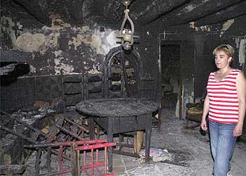 En la imagen, la propietaria de una masía contempla el estado en el que ha quedado su casa tras el incendio.