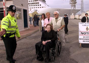 Los pasajeros no afectados por el virus comienzan a bajar del buque.