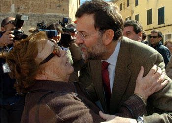 Mariano Rajoy besa a una simpatizante del PP durante un paseo por la ciudad de Mahón.