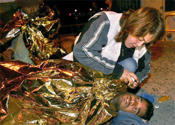 Una facultativa de Médicos Sin Fronteras atiende a uno de los inmigrantes.