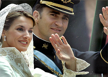 Los novios saludan, durante el recorrido del cortejo nupcial por las calles de Madrid.