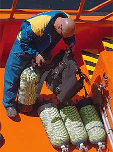 Un buzo de Salvamento Marítimo prepara su equipo a bordo de la lancha  Altair , en el puerto de Malpica.