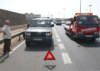 En la imagen, un conductor sufre una avería en la provincia de Sevilla mientras observa el paso de una grúa.