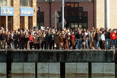 Decenas de vecinos de Santoña esperan en el puerto al barco que traslada el cuerpo de Elías José Gallego.