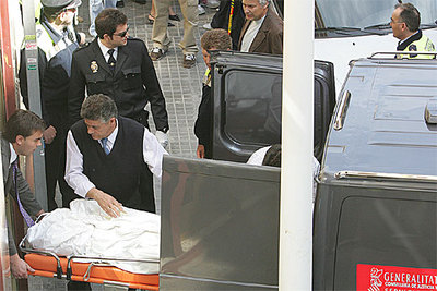 Un empleado del servicio funerario judicial de la Generalitat Valenciana traslada los tres cadáveres.