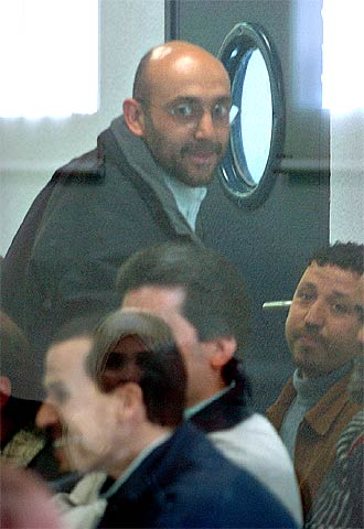 Imad Eddin Barakat Yarkas, alias  Abu Dahdah , de pie, junto a otros acusados en el recinto acristalado desde el que siguen el juicio contra ellos.