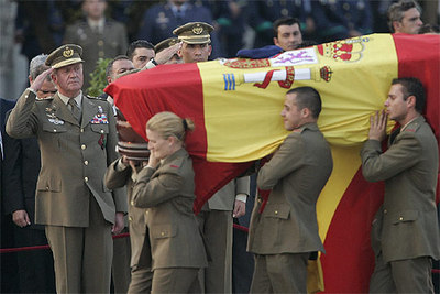 El Rey y el Príncipe saludan al paso de un ataúd, cubierto con la bandera y coronado con la boina del fallecido.