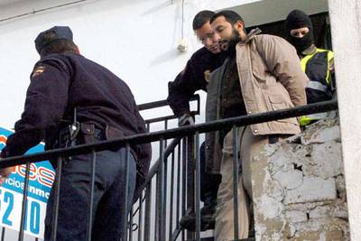 Uno de los 14 detenidos en las últimas horas por la policía en distintas provincias como miembros de un grupo dedicado al reclutamiento de  muyahidines  para Irak, es trasladado a Comisaría desde su domicilio, en la Calle Frascuelo de Málaga.