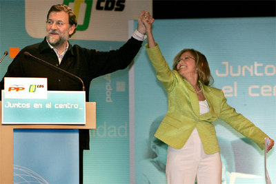 Rajoy levanta el brazo de la presidenta del CDS, María Teresa Gómez Limón, durante el acto de integración de ese partido en el PP.