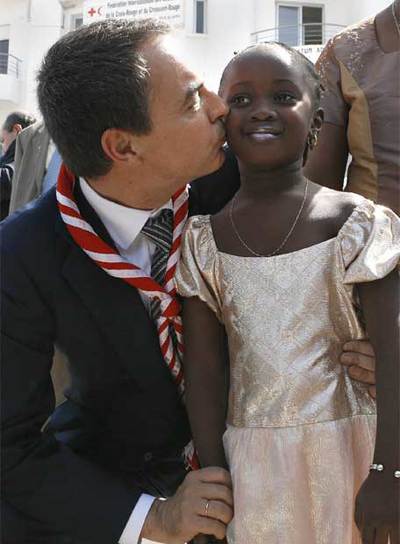 Zapatero besa a una niña senegalesa en la sede de la Cruz Roja en Dakar.