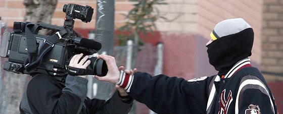 Uno de los jóvenes encapuchados tapa el objetivo de la cámara de uno de los reporteros presentes en los incidentes de hoy en Alcorcón.