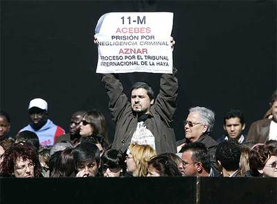 Una de las víctimas exige responsabilidades criminales a Acebes y Aznar en una pancarta.