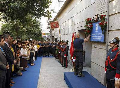Los bomberos depositan flores en la placa.