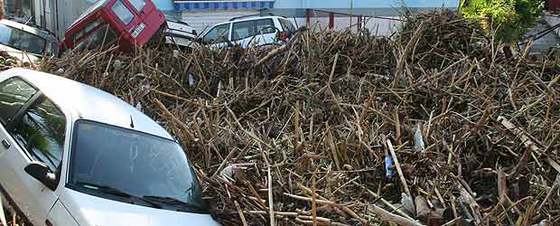 Varios vehículos han quedado amontonados entre basuras y escombros tras ser arrastrados por las fuertes lluvias registradas ayer en la localidad granadina de Almuñecar.