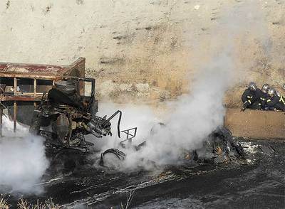 Miembros del cuerpo de Bomberos, junto a la cabina del camión.