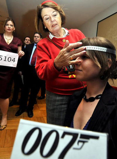 Una aspirante a extra se presta para que le tomen las medidas.