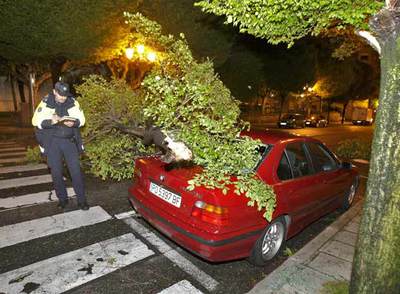 Efectos del temporal que azota Galicia desde esta madrugada. En la imagen, un policía local toma ntoa de un incidente en Vigo