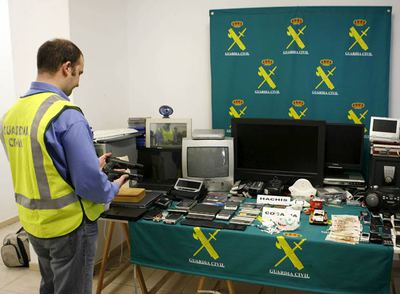 Un agente examina las armas intervenidas al grupo de traficantes de droga desarticulado en los últimos días