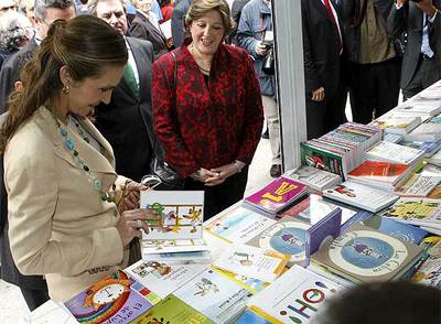 La Infanta Elena hojea un libro en uno de los  stands .