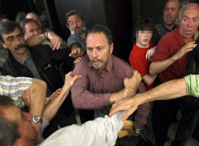 Vicente Itxaso, concejal del PSE en Pasaia, forcejea con simpatizantes de la izquierda  abertzale  en el pleno celebrado esta tarde.