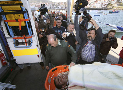 Agentes de la Guardia Civil sacan en camilla al supuesto agresor del capitán del mercante  Paxi C .