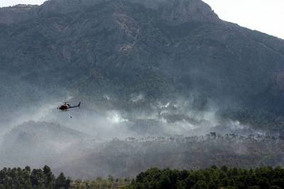 Unos doce medios aéreos (avionetas y helicópteros bombarderos) colaboran con la extinción del fuego en el Parque Natural de Els Ports