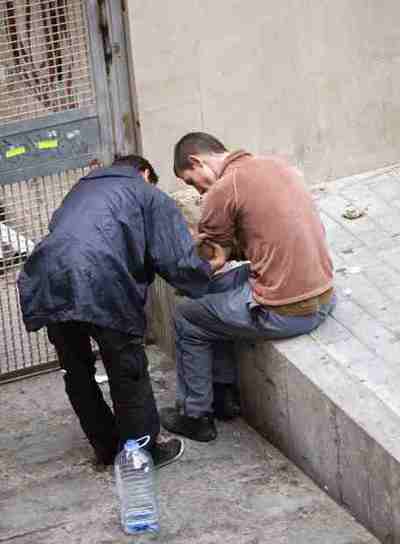 Unos jóvenes pinchándose en las inmediaciones de la narcosala del Raval, en la calle Arc del Teatre de Barcelona.