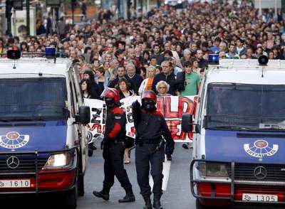 Agentes de la Ertzaintza escoltan la manifestación convocada por el Movimiento Pro Amnistía en San Sebastián.