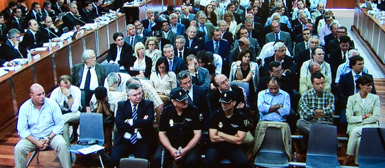 El banco de los acusados, donde se puede ver al ex asesor de urbanismo del Ayuntamiento de Marbella, Juan Antonio Roca (2i), tomada desde uno de los monitores en la sala de prensa de la Audiencia Provincial de Málaga.