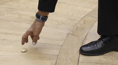 Un diputado recoge la piedra que Luna ha dejado caer desde la tribuna.