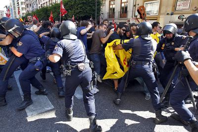 Los policías antidisturbios cargan contra un grupo de jóvenes en el centro de Valencia.