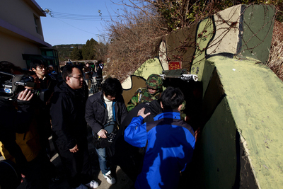 Marineros surcoreanos, residentes y periodistas ingresan a un refugio subterráneo hoy, domingo 28 de noviembre de 2010, en la Isla de Yeonpyeong (Corea del Sur). La agencia de noticias Yonhap reportó que Corea del Sur estuvo considerando clasificar a su vecino del norte como su 