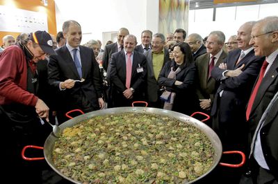 El presidente valenciano, Francisco Camps, prueba una paella durante su visita, ayer, a la feria Fruit Logística de Berlín.