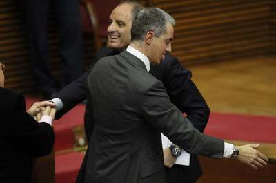 El presidente valenciano, Francisco Camps, junto a Ricardo Costa,  saluda a un diputado en las Cortes tras la sesión de control.