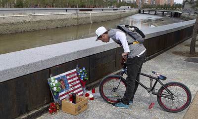 Velas y flores en memoria de Austin en el lugar donde se halló su cadáver, junto a un cartel que denuncia su 