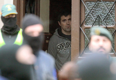 12072011. Igor Esnaola Dorronsoro, uno de los dos presuntos miembros de ETA detenidos esta madrugada en Legorreta (Guipúzcoa), al que se acusa junto a su hermano Jon Aitor de ser miembros del aparato de logística de la organización terrorista, encargados de distribuir armas y explosivos al resto de la banda, es custodiado esta mañana por agentes de la Guardia Civil tras registrar su domicilio.