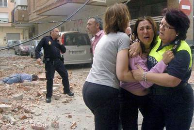 Una policía y una vecina de Lorca consuelan a una mujer.