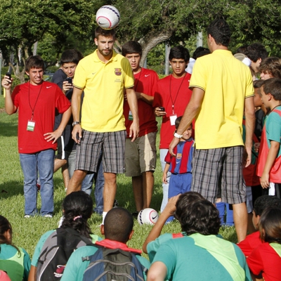 Gerard Piqué y Sergio Busquets (de espaldas) juegan rodeados por un grupo de niños ayer en Miami.
